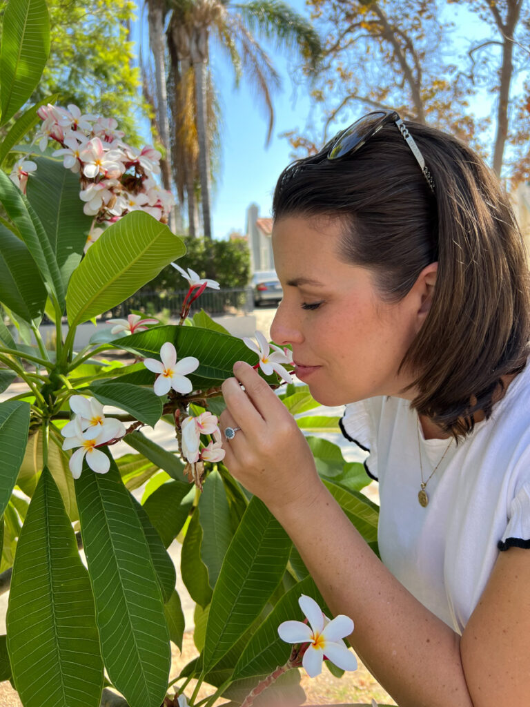 woman smelling plumeria flower